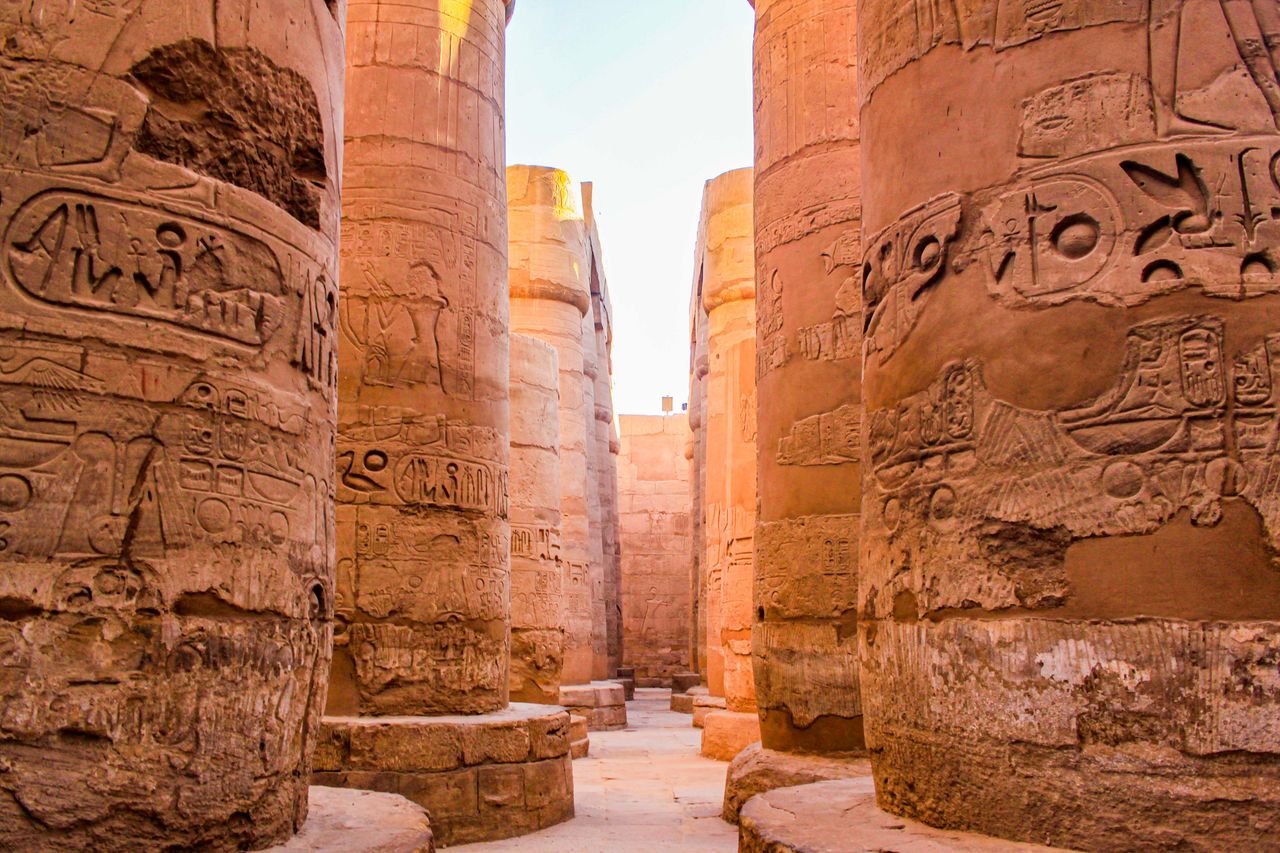 Explore the grandeur of ancient Egyptian columns adorned with hieroglyphic carvings.